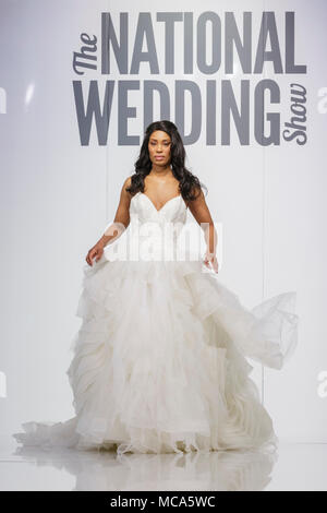 ExCel London, Londres, 14 avril 2018. Un modèle montre un beau mariage dess sur les podiums.Le Mariage National Show a lieu au centre des expositions ExCel London ce week-end, mettant en valeur les dernières tendances, suite nuptiale, robes et accessoires tout autour de la planification du mariage parfait. Credit : Imageplotter News et Sports/Alamy Live News Banque D'Images