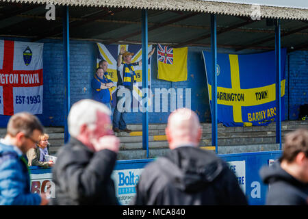Trois partisans de la ville de Warrington se placer devant leurs drapeaux derrière l'objectif au Throstle Nest, Farsley pendant le match entre Warrington Town FC et Farsley Celtic le 14 avril 2018 où Warrington a gagné 2 - 0 Crédit : John Hopkins/Alamy Live News Banque D'Images