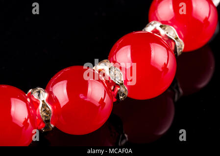 Partie de pearl bracelet rouge sur fond noir Banque D'Images