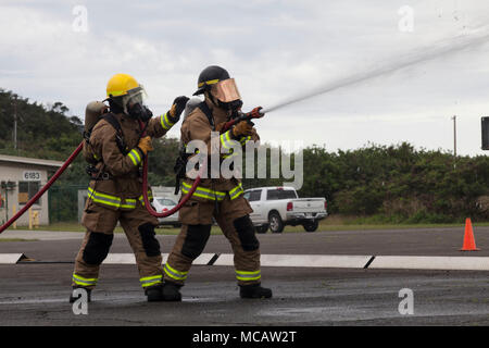 Aircraft Rescue Fire Fighting est une capacité d'intervention d'urgence spécialisée au sein des unités d'aviation du Marine corps. L'image d'archive documente un exercice d'entraînement au tir de roues à feu réel mené à la Marine corps Air Station Kaneohe Bay en février 2018. Le tirage photographique historique enregistre la réponse de l'équipe de tuyaux à l'aide d'un dispositif mobile d'entraînement à la lutte contre les incendies. Banque D'Images