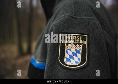 03 avril 2018, l'Allemagne, Werneck : Ralf Petercord, chef de la protection des forêts Ministère de l'Institut forestier du Canada porte un badge sur sa veste qui lit 'Forstverwaltung' (lit. L'administration des forêts). Cette année, les arbres de chêne dans certaines parties de l'état allemand de Bavière faire face à une grave menace de la spongieuse. Photo : Nicolas Armer/dpa Banque D'Images