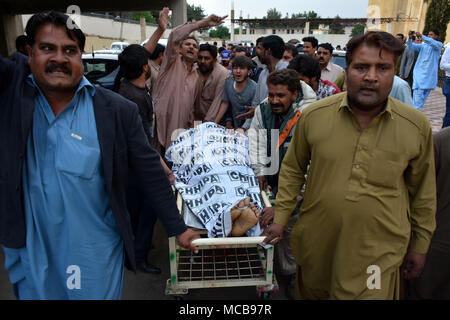 Quetta, Pakistan. Apr 15, 2018. Les gens de transférer le corps d'une victime à l'hôpital suite à une attaque de tir dans le sud-ouest du Pakistan Quetta, le 15 avril 2018. Au moins deux personnes ont été tuées et cinq autres blessées dimanche dans une attaque armée dirigée contre le Pakistan Quetta, dans les médias locaux et de la police a dit. Credit : Asad/Xinhua/Alamy Live News Banque D'Images