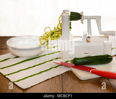 Courgettes en spirale appelé zoodles nouilles préparée en spiralizer gadget cuisine Banque D'Images