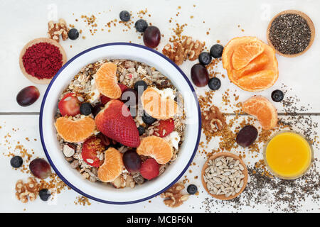 Le petit-déjeuner végétarien sain superfood concept avec fruits, céréales, jus, smoothie, yaourt, grain de pollen d'acai en poudre, les graines de chia et les écrous sur la r Banque D'Images