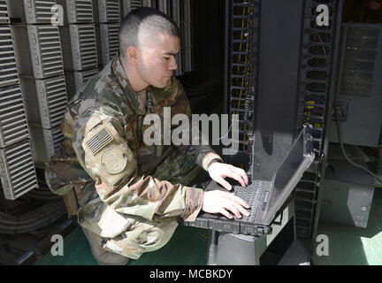 Le s.. Brandon Hasegawa, 455 e Escadron de transport Communication expéditionnaire cyber technicien, active un port réseau 22 mars 2018, à l'aérodrome de Bagram, en Afghanistan. En plus de l'entretien et la gestion du réseau, Hasegawa reste occupé avec des problèmes de vulnérabilité, d'essai et de dépannage de l'équipement des systèmes de réseau ainsi que les activations de port. Banque D'Images