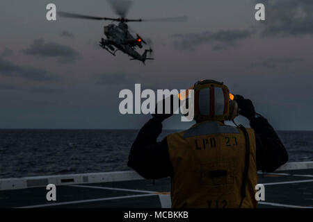 Océan Pacifique (25 mars 2018) l'aviation en chef Maître de Manœuvre (carburant) Horatio Johnson, de Miami, Floride, signaux pour le pilote d'un UH-1Y Venom à partir de l'hélicoptère d'attaque léger détachement de l'escadron 166 à rotors basculants moyen maritime renforcée, l'élément de combat de l'aviation pour la 13e Marine Expeditionary Unit (MEU), de se poser sur le pont d'envol du San Antonio-classe de transport amphibie USS dock Anchorage (LPD 23), au cours d'un escadron amphibie et MEU intégration (PMINT) de l'exercice. PMINT est une évolution de la formation entre l'Essex et le 13e Groupe amphibie MEU, qui permet aux marins et Mari Banque D'Images