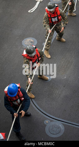 Marins et soldats de la Marine américaine tirez une ligne à bord du USS Rushmore (LSD 47) lors d'un escadron amphibie et Marine Expeditionary Unit (MEU) intégration (PMINT) exercice en mer, le 30 mars 2018. PMINT est une évolution de la formation entre l'Essex et le groupe amphibie 13e MEU, qui permet aux marins et soldats à s'entraîner comme une unité cohérente en vue de leur prochain déploiement. Banque D'Images