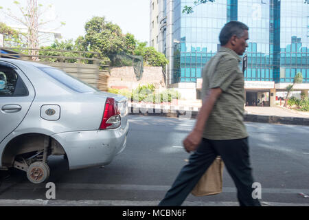 HYDERABAD, INDE - AVRIL 03,2018.Un homme passe devant une voiture sans roue soutenue par le cric hydraulique se trouve sur une rue à Hyderabad, Inde Banque D'Images