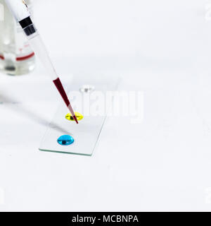 Goutte de sang sur la lame de verre pour groupage sanguin à l'aide de micro-embout Banque D'Images