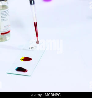 Goutte de sang sur la lame de verre pour groupage sanguin à l'aide de micro-embout Banque D'Images
