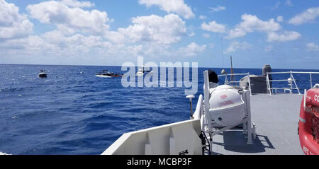 Les garde-côte William Flores se distingue par d'aider comme deux boatcrews récupération commerciale d'aider le navire à moteur de 65 pieds, siempre Sonando, qui prenait l'eau à environ 14 milles à l'est de North Miami Beach Vendredi, 30 mars 2018. La Garde côtière de quart a reçu une radiobalise de détresse et un appel par radio VHF-FM canal 16 à partir de la motor vessel stipulant qu'ils ont abandonné le navire avec huit personnes. Banque D'Images