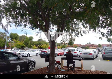 Musicien ambulant jouant du piano électrique sur l'île de la circulation dans le parking de supermarché, Inglewood, Perth, Australie occidentale. Pas de monsieur ou PR Banque D'Images