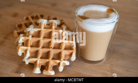 Tasses de café en verre multicouche avec syrupwaffles mini stroopwafel, cookies sur fond de bois clair avec copie espace. waffle cookies Banque D'Images