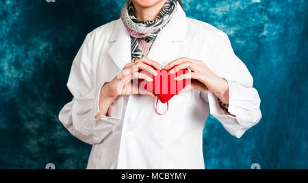 Female doctor holding un cœur rouge close up Banque D'Images
