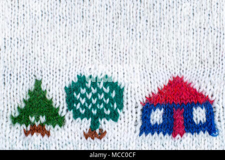 Maison de bonneterie d'arbres sur fond tricoté blanc. Banque D'Images