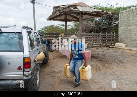 Un homme porte deux bidons d'essence pour le remplissage d'une voiture à une station petro rural. La Colombie, l'Amérique du Sud. Banque D'Images