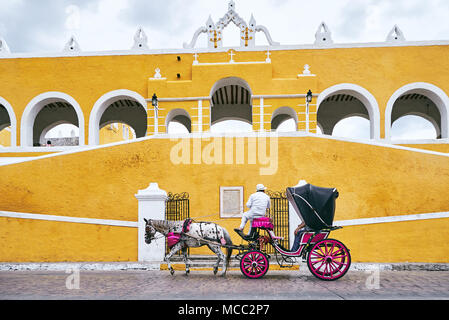 La calèche devant la façade de l'église, le Convento de San Antonio. La ville jaune d'Izamal, Yucatan, Mexique Banque D'Images