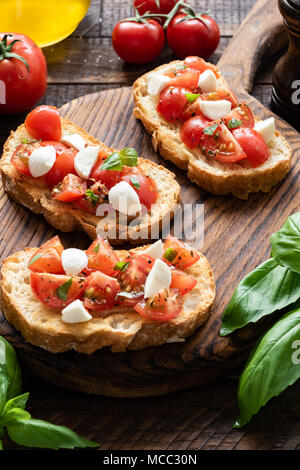 Bruschetta Tomate et mozzarella sur une planche de bois. Selective focus Banque D'Images