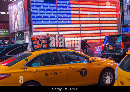 La vitesse de la cabine jaune néon géant passé US flag sur New York City's Times Square, Avril 2018 Banque D'Images