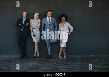 Portrait de groupe multiethnique des collègues d'affaires rire contre un mur. Équipe de professionnels d'affaires kissing togethe Banque D'Images