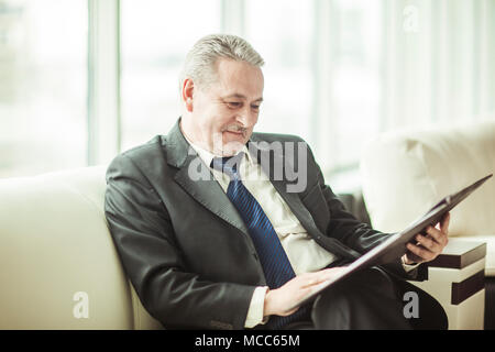Documents de travail études homme assis sur le canapé dans le bureau privé Banque D'Images
