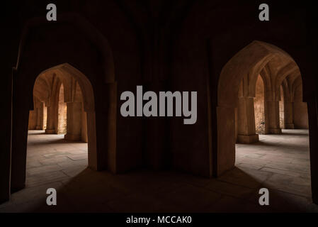 Mandu Inde, ruines de l'islam afghan royaume, l'intérieur du palais, mosquée monument et tombe musulmane. De soleil porte dans couloir sombre. Banque D'Images