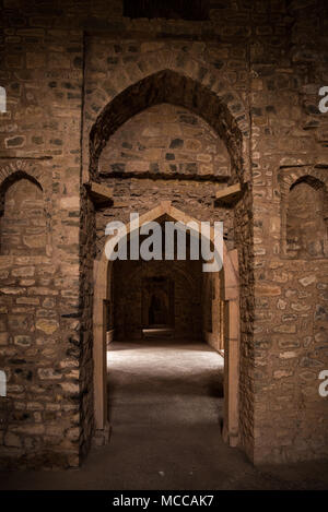 Mandu Inde, ruines de l'islam afghan royaume, l'intérieur du palais, mosquée monument et tombe musulmane. De soleil porte dans couloir sombre. Banque D'Images