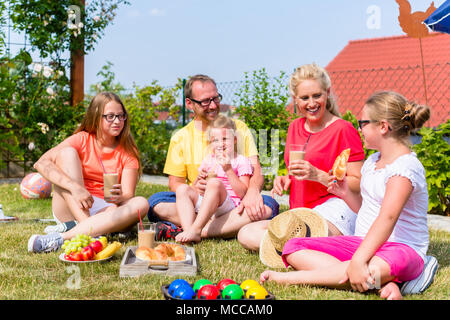 Ayant de la famille en pique-nique jardin avant de leur accueil Banque D'Images