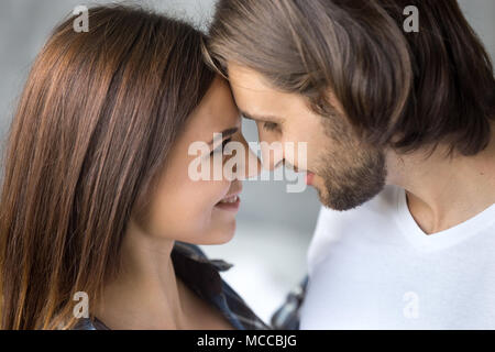 Belle jeune couple face to face close up portrait côté, heureux aimer smiling man and woman enjoying sentiments à la recherche dans les yeux se rapprocher fo Banque D'Images