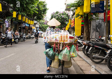 Hanoi, Vietnam - Mai 18, 2016 : vendeur de rue de derrière à l'aide d'un vélo pour transporter des objets à vendre dans la vieille ville d'Hanoi( Pho Co Hanoi). Banque D'Images