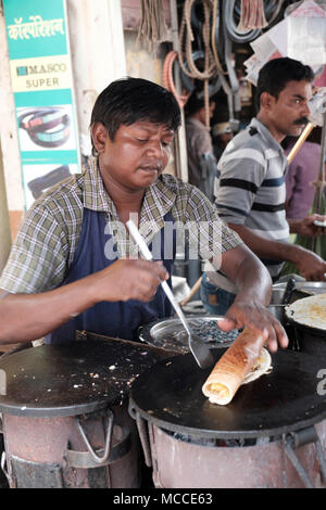 Faire cuire le Masala Dosa sur une plaque chaude en plein air dans un marché de Mumbai Banque D'Images