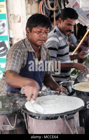 Faire cuire le Masala Dosa sur une plaque chaude en plein air dans un marché de Mumbai Banque D'Images