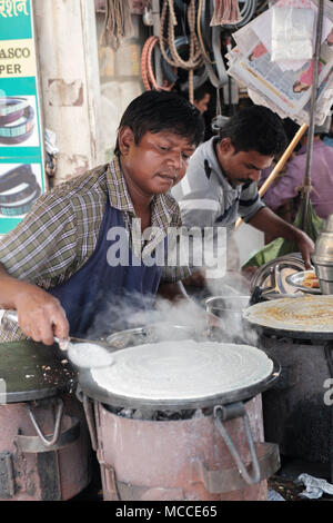 Faire cuire le Masala Dosa sur une plaque chaude en plein air dans un marché de Mumbai Banque D'Images