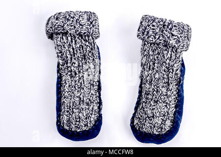 Chaussettes tricotées chaud naturel pour les enfants. Close up de chaussettes tricotées gris avec semelles en velours, fond blanc. Chambre d'hiver mignon chaussons. Banque D'Images