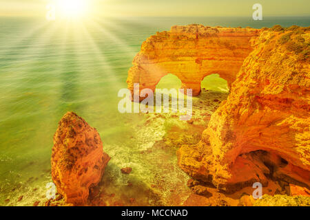 Vue aérienne d'arches naturelles emblématiques de Praia da Marinha en Algarve, Portugal, Europe. Rayons sur la plage de Marinha, l'une des 100 plus belles plages du monde. Lieu célèbre pour les vacances d'été Banque D'Images