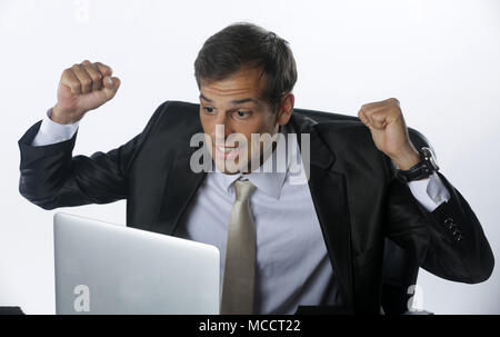 Les jeunes ont souligné handsome businessman working at desk in office moderne en criant à l'écran du portable et d'être en colère au sujet de la situation financière, jaloux de r Banque D'Images