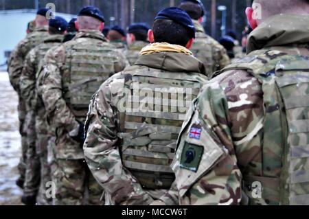 Royaume-uni, les soldats affectés à Balaklava Troop, Light Dragoons et du Groupement tactique en formation stand de la Pologne lors de la cérémonie d'ouverture pour le début de l'exercice Puma, un exercice visant à tester les fonctions d'interopérabilité du groupement tactique de la Pologne et de son état-major supérieur, la 15e Brigade mécanisée, près de Bemowo Piskie Domaine de formation, la Pologne le 12 février 2018. La Pologne est un groupe de combat, l'unique groupe de combat multinationale, composée d'Américains, Britanniques, croate et soldats roumains qui servent avec la 15e Brigade mécanisée polonaise comme une force de dissuasion dans le nord-est de la Pologne à l'appui de la NAT Banque D'Images