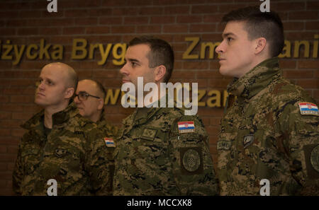 Des soldats croates ont bénéficié d'une visite guidée par le général polonais Jarosław Gromadziński, la 15e Brigade mécanisée, commandant à travers une histoire afficher lors d'une célébration culturelle croate lors de la 15e Brigade mécanisée polonaise, la Pologne, l'administration centrale le 12 février 2018. La multinationale unique, groupement tactique est composé d'États-Unis, Royaume-Uni, croate et soldats roumains servir avec la 15e Brigade mécanisée polonaise comme une force de dissuasion dans le nord-est de la Pologne à l'appui de l'OTAN vers l'amélioration de la présence. (U.S. Photo de l'armée par la CPS. Andrew McNeil/ Mobile 22e Détachement des affaires publiques) Banque D'Images