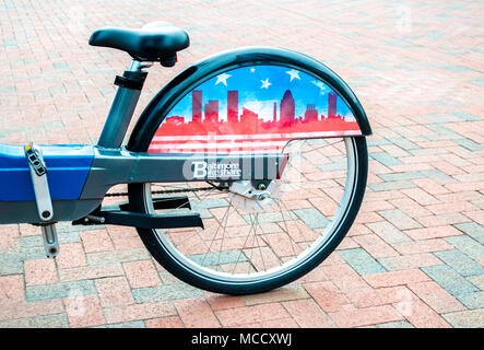 Roue arrière vélo de la part de vélo Baltimore programme sur une allée en brique le port intérieur de Baltimore Maryland USA Banque D'Images