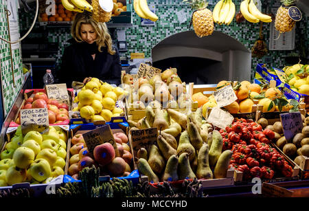 Une dame se trouve derrière son étal de fruits dans la Via Pescherie Vecchie, Bologne, Italie Banque D'Images