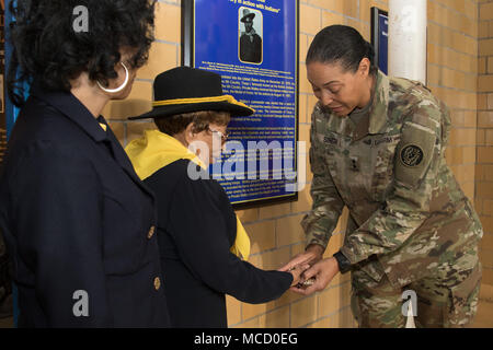 Le général de Linda Singh, l'adjudant général du Maryland, présente son défi coin à Betty Stokes, la nièce d'Auguste grand Walley après dévoilement de la plaque consacrant la Guilded Age prix dans le Maryland Musée d'histoire militaire à la Cinquième Regiment Armory à Baltimore, le 13 février 2018. Walley, un Buffalo Soldier, a reçu la médaille d'honneur du Congrès pour sauver d'autres soldats qui étaient sous un feu nourri de l'Apache. (U.S. Photo de la Garde nationale par le Cpl. Elizabeth Scott) Banque D'Images