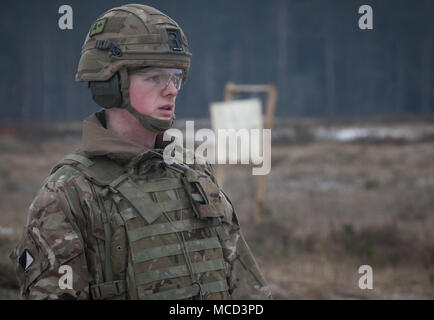 Un soldat britannique avec le Light Dragoons attend de recevoir des directives, comme il se prépare à ses feux 5,56 millimètres-light machine gun à une gamme près de la zone d'entraînement Bemowo Piskie, Pologne, le 15 février 2018. Ce soldat est une partie de l'unique groupe de combat multinationales, composé de États-Unis, Royaume-Uni, croate et soldats roumains qui servent avec la 15e Brigade mécanisée polonaise comme une force de dissuasion dans le nord-est de la Pologne à l'appui de l'OTAN vers l'amélioration de la présence. (U.S. Photo de l'armée par la CPS. Andrew McNeil/ Mobile 22e Détachement des affaires publiques) Banque D'Images