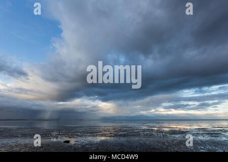 Des nuages au-dessus de l'estuaire de la plage Seasalter Swale, Whitstable, Kent, UK avec une vue vers l'île de Sheppey. Banque D'Images