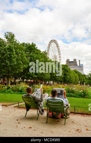 Un couple lisant le journal à l'Tuellieries jardins du Louvre à Paris. Banque D'Images