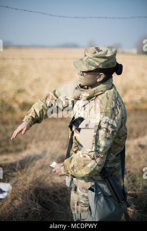 La CPS de l'armée américaine. Sandra Cruz, affecté à la police militaire américaine à Schinnen Garnison Benelux, communique avec les mains et les signaux d'armes de la garnison pendant la compétition meilleur guerrier sur la base aérienne de Chièvres, Belgique, le 21 février 2018. (U.S. Photo de l'armée par Visual Spécialiste de l'information, Pierre-Etienne Courtejoie) Banque D'Images