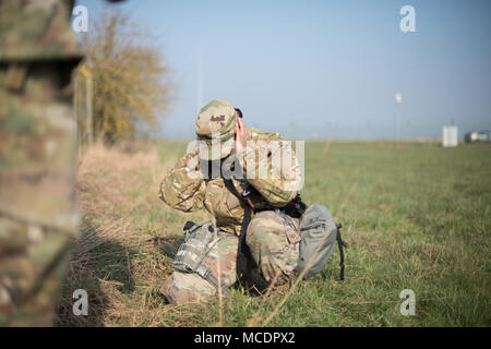 La CPS de l'armée américaine. Sandra Cruz, affecté à la police militaire américaine à Schinnen Garnison Benelux, montre comment protéger ses oreilles après avoir jeté une grenade à main pendant la compétition meilleur guerrier de la garnison sur la base aérienne de Chièvres, Belgique, le 21 février 2018. (U.S. Photo de l'armée par Visual Spécialiste de l'information, Pierre-Etienne Courtejoie) Banque D'Images