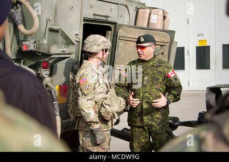 Le brig. Gen. Michel-Henri St Louis (Canada), général commandant adjoint pour les opérations de Corps à Joint Base Lewis-McChord, Washington parle avec le personnel. Le Sgt. Colt Dietrich, d'un obusier chef de section, affecté à la batterie d'artillerie, Archer, 2d de l'escadron de cavalerie, sur la façon dont un véhicule de combat Stryker remorque une M777. Dietrich a donné de la rétroaction sur la façon dont un Stryker aurait besoin d'être modifiés d'un obusier de l'équipage et leur équipement au cours d'une mission. La présentation a eu lieu le 22 février 2018 à la FA motorpool. (Photo : Le s.. Jennifer Bunn) Banque D'Images