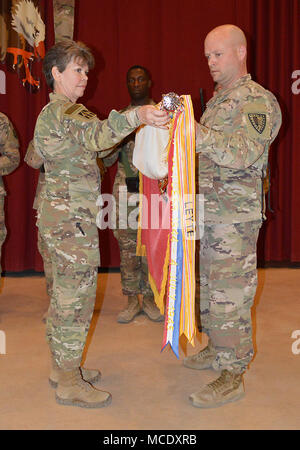 Le Cpl. Devin McElveen , tient la 38e Brigade de soutien couleurs que le colonel Kimberly Martindale, commandant de la 38e, et commande le Sgt. Le Major Scott Andrews, principal conseiller de la brigade s'est enrôlé, déploie les couleurs lors d'une cérémonie de transfert d'autorité s'est déroulée au Camp Arifjan, au Koweït, le 26 février. La brigade a reçu le commandement et le contrôle de la 371e Brigade de soutien. (Photo par le Sgt. Brad Staggs, 38e Sus. Le BDE. Affaires publiques) Banque D'Images