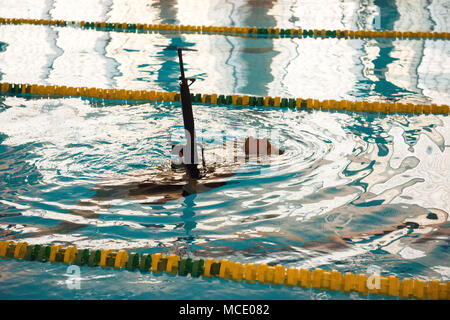 Le sergent de l'armée américaine. Jacobus Bois, affecté à la Police militaire de Bruxelles à la U.S. Army Garrison Benelux, nage tout en gardant la plupart de ses armes hors de l'eau au cours de la garnison's Best Warrior la concurrence dans la piscine du Grand Quartier général des Puissances alliées en Europe, Belgique, le 21 février 2018. (U.S. Photo de l'armée par Visual Spécialiste de l'information, Pierre-Etienne Courtejoie) Banque D'Images