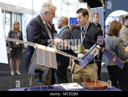 180410-N-ONU340-003 National Harbor, MD (avr. 10, 2018) Norme Heuss, Chef du personnel, responsable de programme (le Bureau) Échanges de systèmes spatiaux, des cartes d'affaires avec un officier de marine en discutant de nanosatellites dans la marine La guerre de l'information sur le pavillon de la mer de 2018, l'air et l'espace exposition (SAS). Le pavillon de la guerre de l'information est présentée par un partenariat entre le Bureau de l'administrateur en chef des opérations navales de la guerre de l'information (OPNAV N2N6) ; commandant de la flotte américaine commande Cyber/Commander, U.S. 10e flottille (CFCC/C10F) ; Space and Naval Warfare Systems Command (SPAWAR) et com Banque D'Images